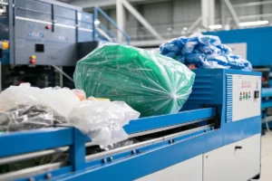 Close-up of plastic materials being processed in a molding machine, showcasing bags of raw plastic materials.