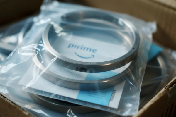 The image shows multiple high-precision metal rings, each sealed in transparent plastic bags for protection. Inside each package is a paper insert printed with the "Prime" logo and product documentation. These components appear to be ready for shipment, neatly packed in a cardboard box, reflecting attention to quality assurance and professional packaging standards.