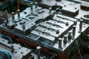 Close-up of a precision metal stamping die set with machined cavities for OEM sheet metal parts in an industrial tooling workshop.