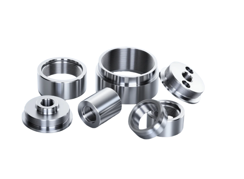 Group of customized CNC turned metal cylinder parts with internal threads and precision drilled holes.