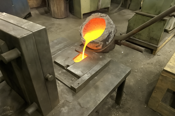 Molten metal being poured into a permanent steel mold for the gravity die casting process.